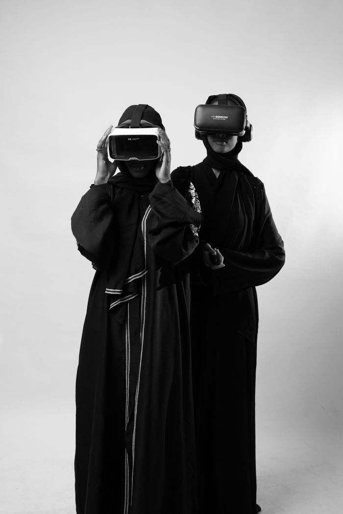 Two people using VR headsets in monochrome setting, showcasing virtual reality technology.